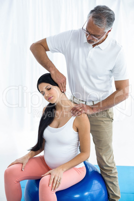 Doctor giving physiotherapy to pregnant woman