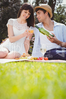 Young man pours to woman wine in a glass