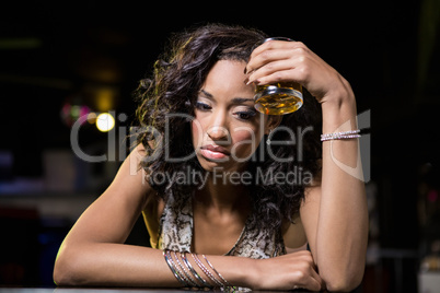 Depressed woman having beer at whiskey counter Depressed woman having beer at whiskey counter