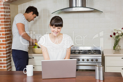 Woman using laptop in kitchen