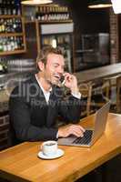 Thoughtful man using laptop and smartphone