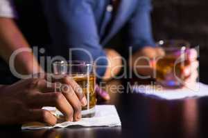 Two men having whiskey at bar counter