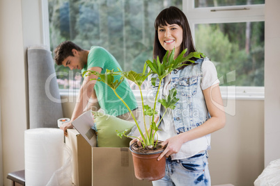 Young couple unpacking carton boxes in their new house