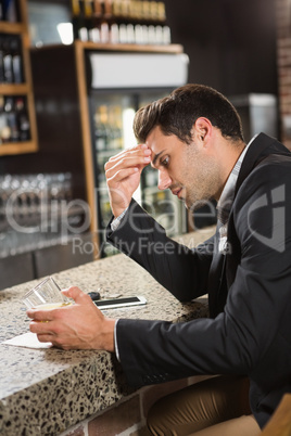 Tired man looking at his whiskey