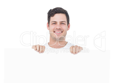 Handsome man holding a white poster