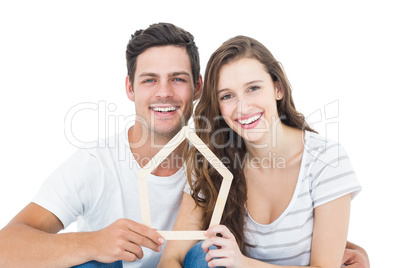 Happy couple holding house shape