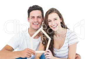 Happy couple holding house shape