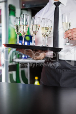 Mid section of bartender serving champagne