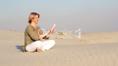 woman play with tablet in desert