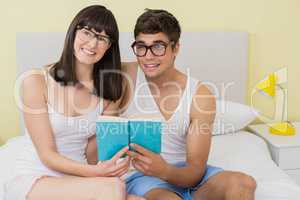 Young couple reading a novel on bed