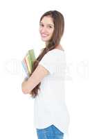 Side view of smiling female college student holding books