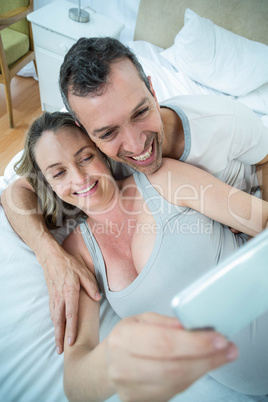 Expecting couple lying on bed