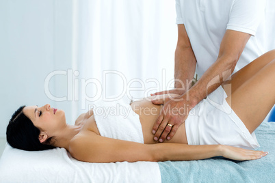 Pregnant woman receiving a stomach massage from masseur