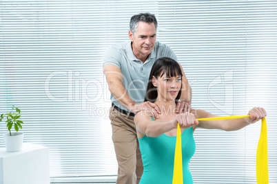 Physiotherapist guiding pregnant woman with exercise