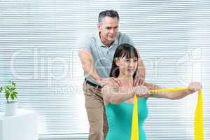 Physiotherapist guiding pregnant woman with exercise