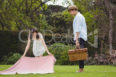 Woman putting picnic blanket in garden