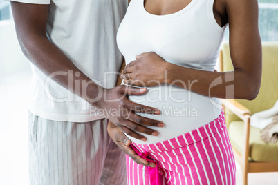 Pregnant couple embracing in bedroom