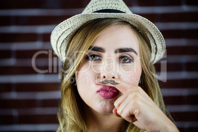 Pretty blonde woman doing a moustache with her finger
