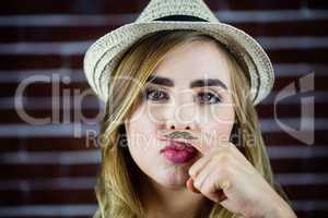 Pretty blonde woman doing a moustache with her finger