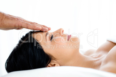 Pregnant woman receiving a head massage from masseur