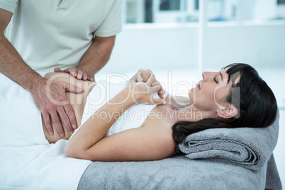 Pregnant woman receiving a stomach massage from masseur