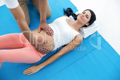 Doctor giving physiotherapy to pregnant woman