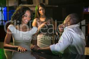 Unhappy woman looking at a couple flirting near bar counter