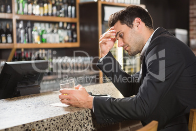 Tired man looking at his whiskey