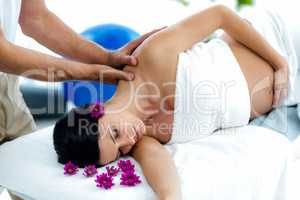 Pregnant woman receiving a back massage from masseur