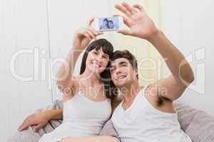Couple lying on sofa and taking a selfie
