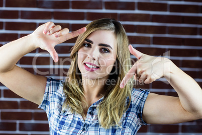 Pretty blonde woman making signs with her fingers