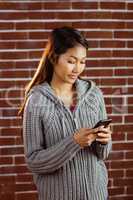 Focused asian woman using smartphone