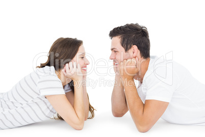 Happy couple lying on the floor looking to each other