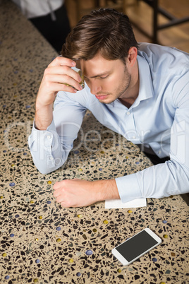 Tired man leaning his elbow on the counter