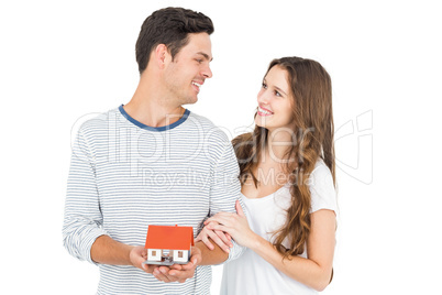 Happy couple holding miniature house