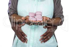 Pregnant couple holding baby shoes