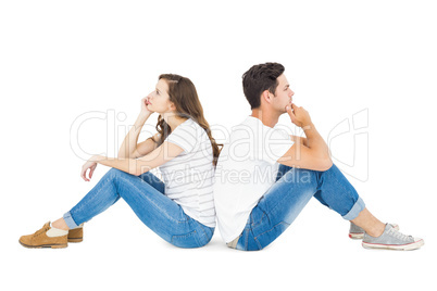 Thoughtful couple sitting on floor back to back