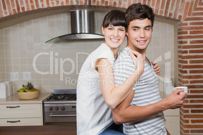 Young woman embracing man in kitchen
