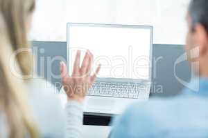 Couple using laptop in living room