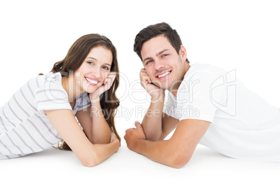 Happy couple lying on the floor looking at the camera