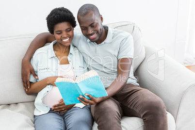 Pregnant couple reading a book