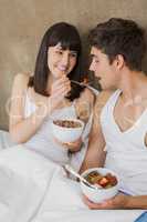 Woman feeding breakfast cereals to man