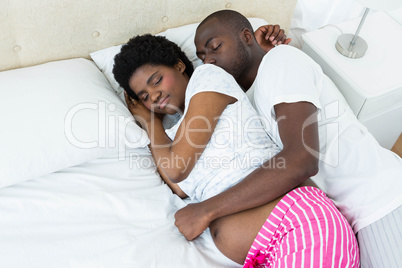 Pregnant couple relaxing on bed