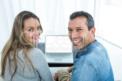 Couple using laptop in living room