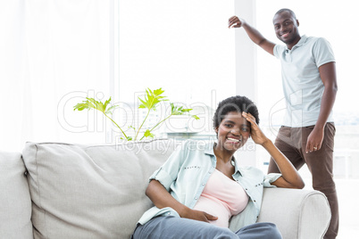 Happy pregnant couple in living room