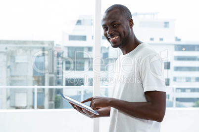 Man using digital tablet near window