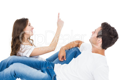 Happy couple lying on the floor pointing up