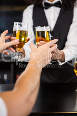 Female bartender serving beer at bar counter