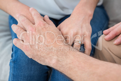 Close-up of man and woman holding hands