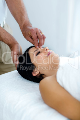 Pregnant woman receiving a head massage from masseur